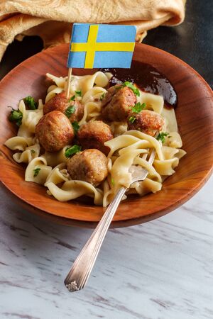 Swedish meatballs with mini flag toothpick noodles gravy and jelly in wooden bowlの写真素材