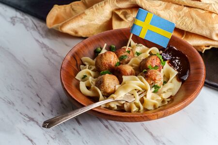 Swedish meatballs with mini flag toothpick noodles gravy and jelly in wooden bowlの写真素材