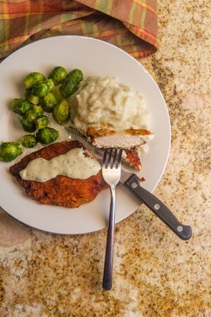 Baked breaded chicken cutlets with brussels sprouts and mashed potatoesの写真素材