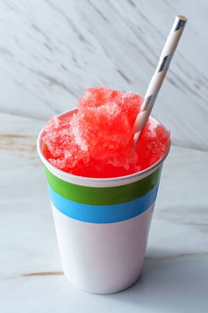 Cherry red summer slushy with biodegradable paper strawの写真素材