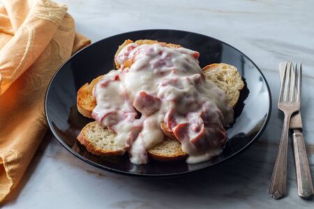 Creamed and chipped beef on sliced toast on marble kitchen table also known as S.O.S.の写真素材