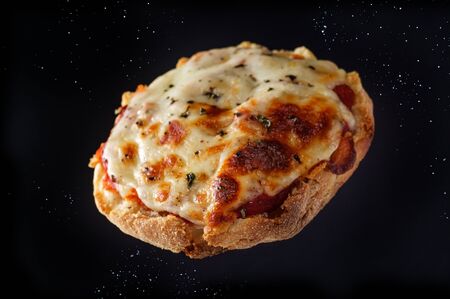 Fresh baked homemade English muffin pizzas flying through the airの写真素材