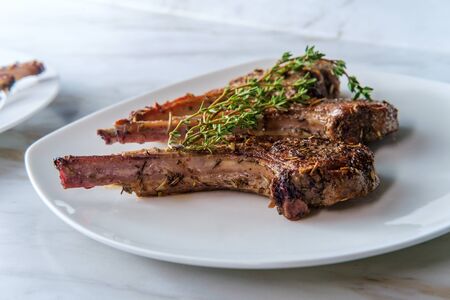 Fancy and simple marinated French lamb rib with thyme garnish
