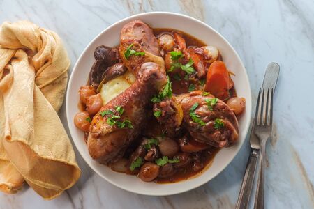 French cuisine Coq Au Vin stew with crimini mushrooms pearl onions and carrots in a red wine brandy sauce served over mashed potatoesの写真素材