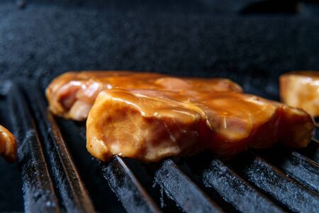 Marinated pork chops cooking on the grill with honey barbecue sauce glazeの写真素材