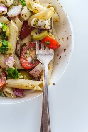 Gluten free Italian pesto pasta salad with pearl mozzarella cheese balls and halved cherry tomatoesの写真素材