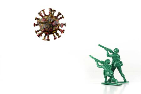Green toy army men attack and fight off the coronavirus as metaphor for human immune systemの写真素材