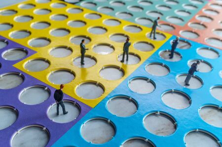 Miniature businessmen practicing social distancing to slow the spread of the deadly coronavirus