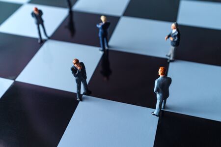 Miniature businessmen practicing social distancing to slow the spread of the deadly coronavirusの写真素材