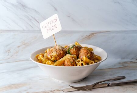 Italian penne alla carbonara pasta dish with sausage meatballs and spinach