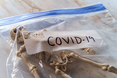 Toy skeleton in plastic bag labeled COVID-19 to symbolize the death toll from the coronavirus
