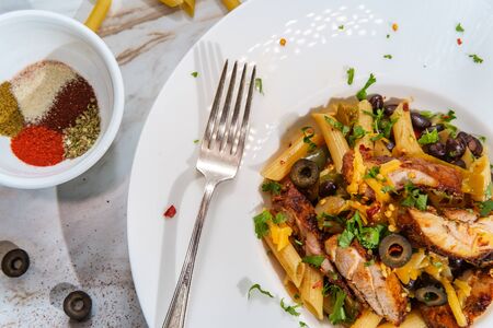 Chicken fajita pasta with multicolored bell peppers black beans and olivesの写真素材