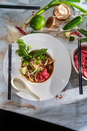 Traditional Vietnamese pho bo beef noodle soup served with noodles basil cilantro mushrooms and bean...