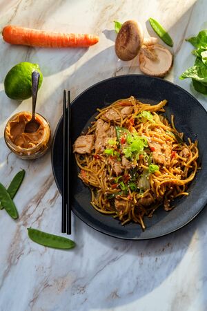 Spicy Thai chicken peanut butter lo mein noodles with sesame seedsの写真素材