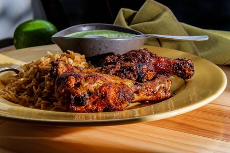 Peruvian chicken legs with aji verde green cilantro sauce and fried riceの写真素材