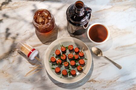 Cocktail hot dogs served with bourbon dipping sauce with glass of whiskey served straight up