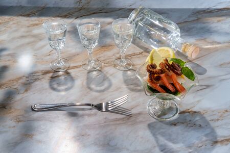 Shrimp and octopus tentacle cocktail appetizer with brunch vodka shots