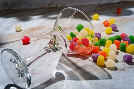 Granulated sugar coated candy gumdrops spilled martini glassの写真素材