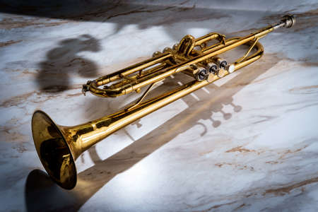Rusty old dented classical trumpet on marble tableの写真素材