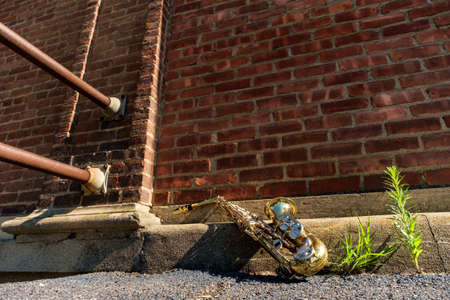 Outdoor Jazz entertainment musical instrument saxophone with grungy street backgroundの写真素材