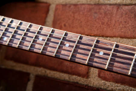 Blue electric guitar against brick wall outside music venue