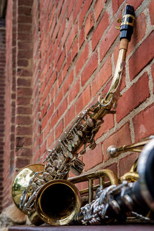 Musical instruments including trombone trumpet clarinet and saxophone on brick wall outside Jazz...
