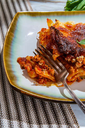 Home made Italian baked cheese and meat lasagna on marble kitchen tableの写真素材
