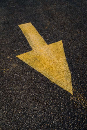 Yellow arrows painted on road or parking lot for directing traffic patternsの写真素材