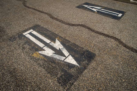 White arrows painted on road or parking lot for directing traffic patterns
