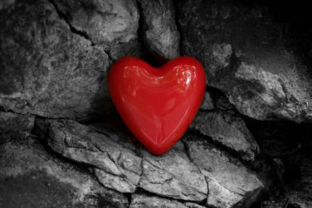 Red shiny romantic Valentine's Day heart on contrasting black and white natural textured background