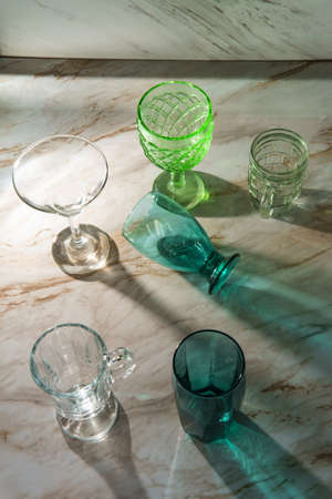 Various shaped drinking glasses on marble kitchen tableの写真素材