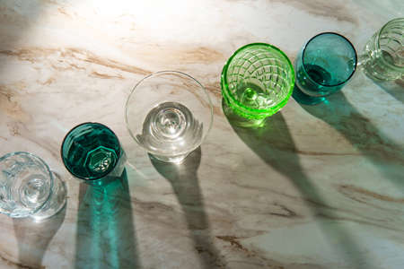 Various shaped drinking glasses on marble kitchen tableの写真素材