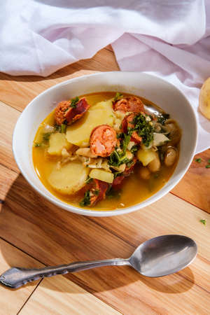 Traditional Portuguese caldo verde linguica sausage soup with kale and yukon gold potatoes