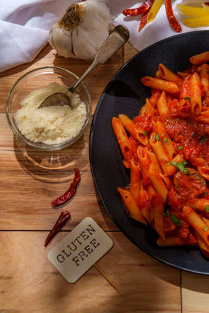 Gluten-free penne pasta in spicy arrabbiata tomato sauce with Italian sausageの写真素材