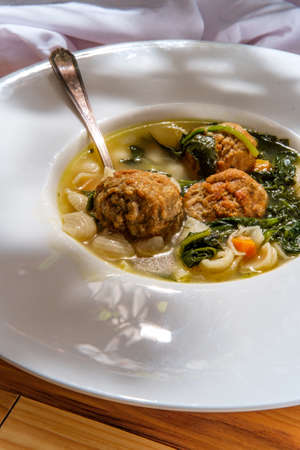 Italian wedding soup with meatballs conchiglie pasta and spinachの写真素材