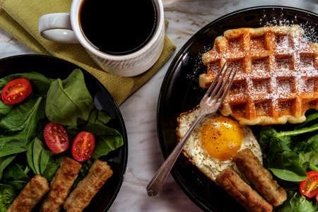 Belgian waffle breakfast served with sausage eggs and coffee