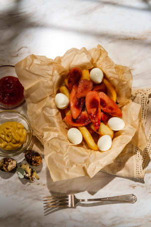 Peruvian fast-food salchipapas french fries and sliced sausage with hard-boiled quail eggs