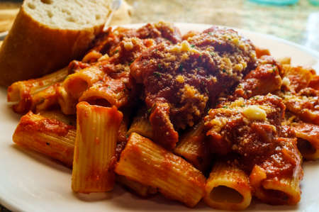 Bolognese braciola with rigatoni and sliced crusty breadの写真素材