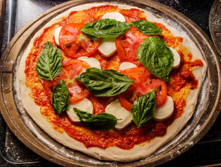 New York style Margherita pizza with fresh mozzarella and basil leaves