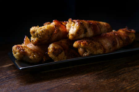Bacon wrapped chicken tenders appetizer with dark moody lighting