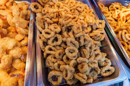 Fresh hot beer battered onion rings in buffet tray serverの写真素材