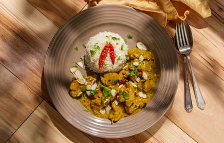 Indian chicken korma curry dinner with basmati rice and almonds