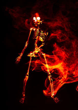 Scary demon Halloween skeleton dances in deadly fireの写真素材