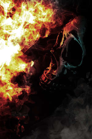 Scary demon Halloween skeleton skull burning in fireの写真素材