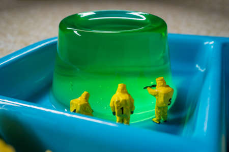 Miniature hazmat team inspecting the nutritional value of unhealthy fast food school lunchの写真素材