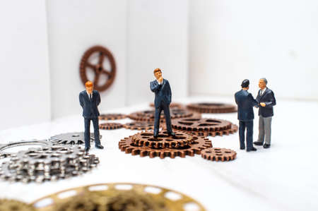 Businessmen surrounded by gears and cogs for innovation conceptual metaphor