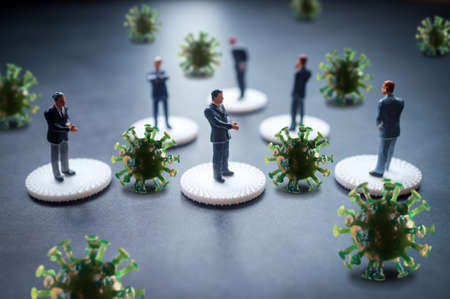 Miniature businessmen practicing social distancing to slow the spread of the deadly coronavirusの写真素材