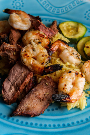 This American surf and turf dinner features char-grilled shrimp with sliced roasted london broil...