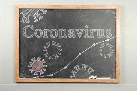 Coronavirus cells illustration drawn on grade school chalkboard with graph lineの写真素材