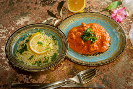 Authentic Indian cuisine chicken tikka masala with coriander and lemon twist garnishの写真素材